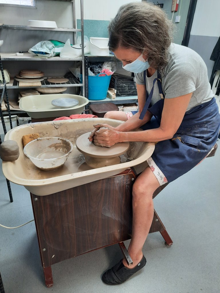 learning a new craft - centering the clay on a potter's wheel