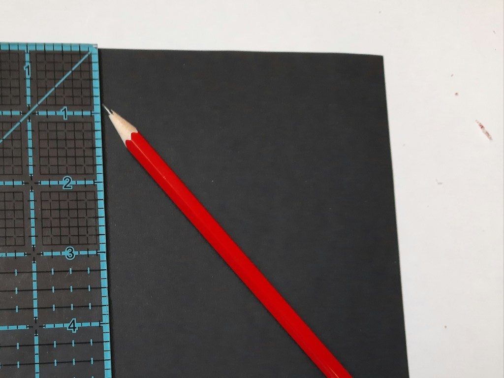 marking the cardboard with a ruler and pencil