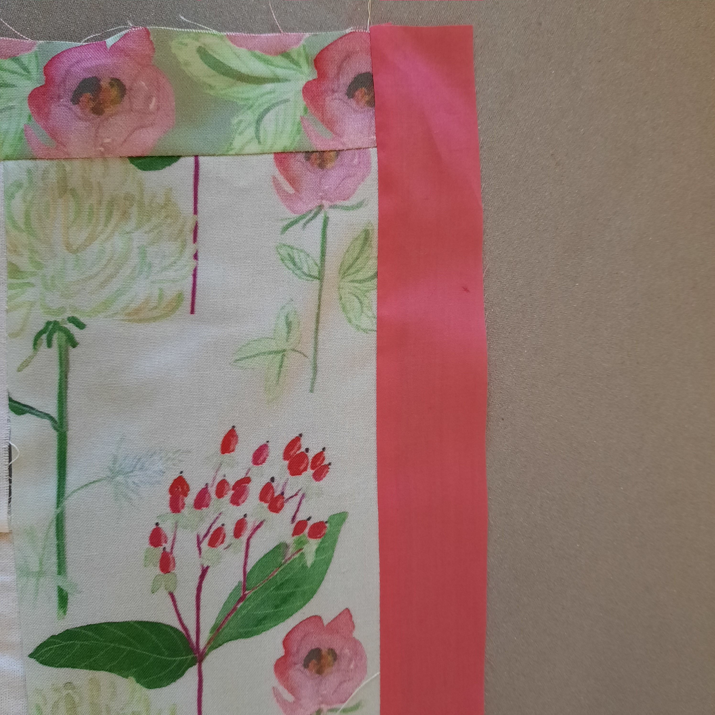 Adding the pink internal border to the 'Summer Bouquets' quilt, the photo shows the narrow roses border at the top and the pink border at the right of the quilt-top