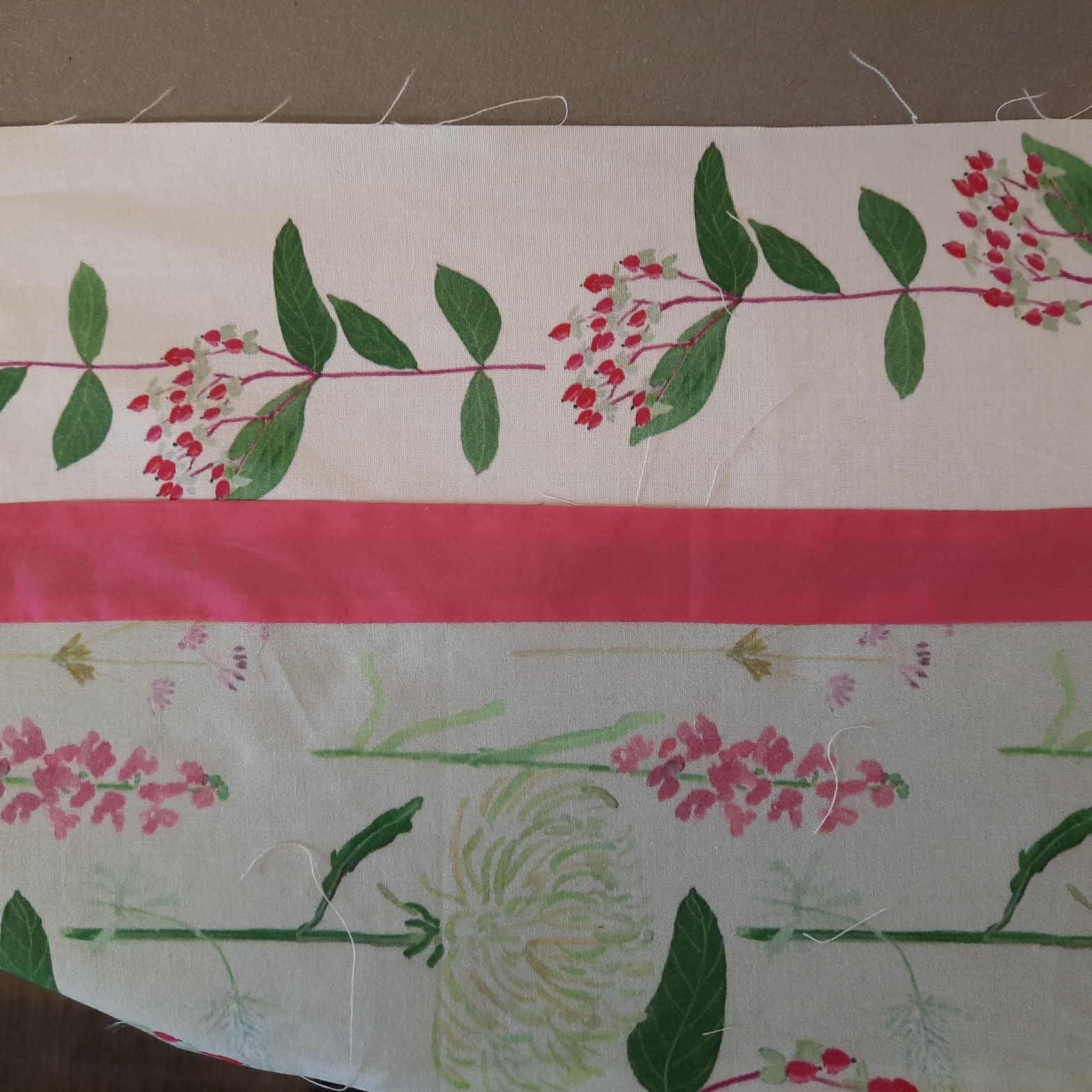 The outer border at the top of the 'Summer Bouquets' quilt, the outer border uses the 'Berries on White' fabric design which is of red berries in a sprig with green leaves