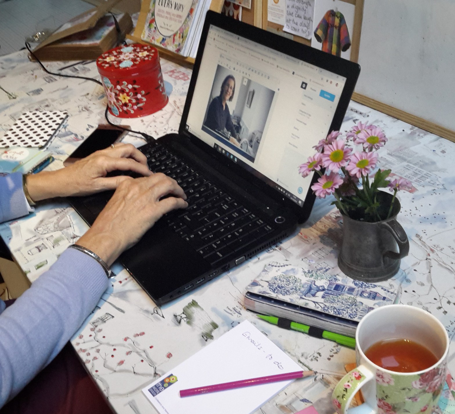Amanda writing her weekly blog at her work desk