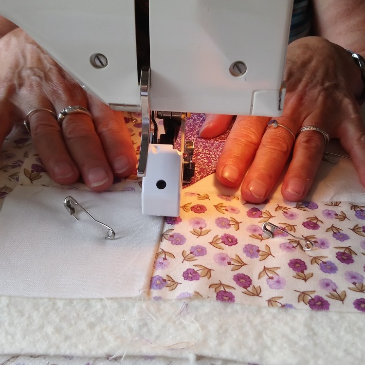 Woman's hands under a sewing machine, to illustrate the 'Quilt in a Day' course from Amanda Ogden