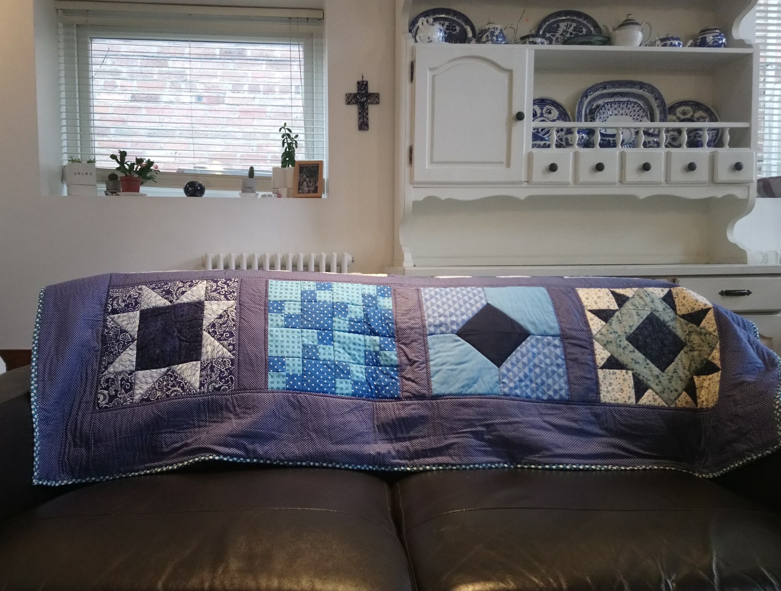 A quilt entitled 'Make a Quilt in 2019' on the back of a sofa