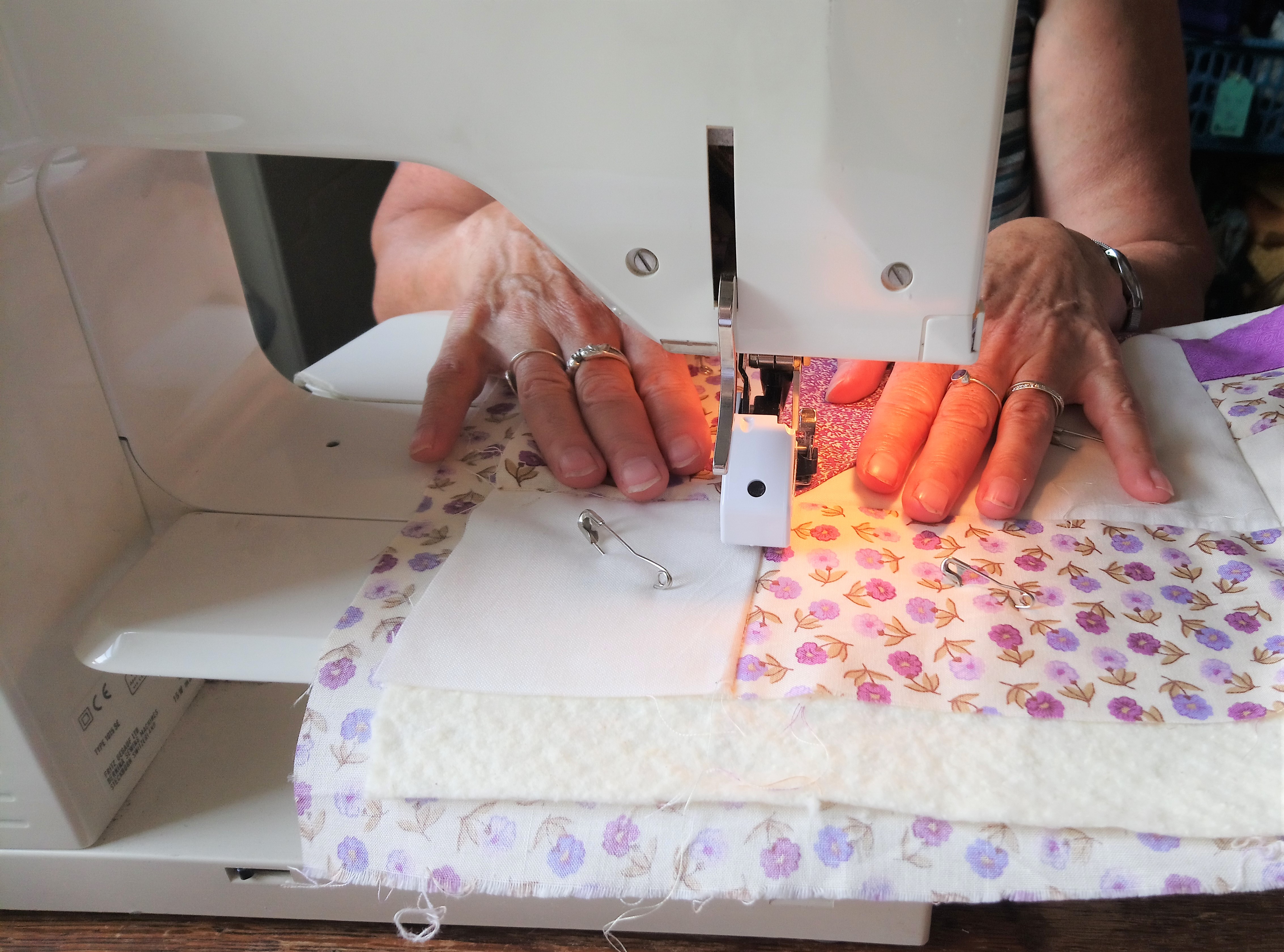 Person at a sewing machine making a quilt during the QUILT IN A DAY class