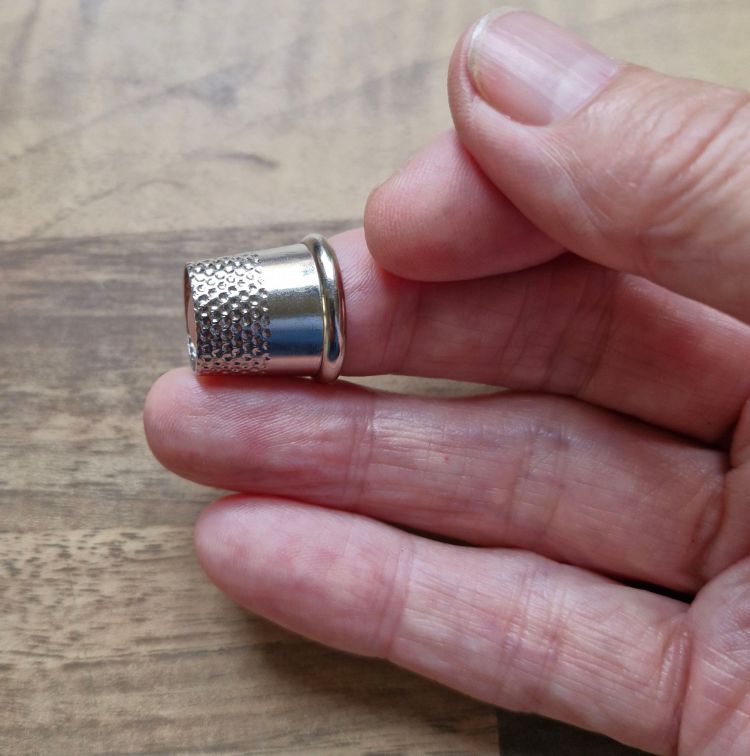 tailor's thimble, worn on the middle finger