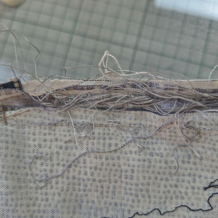 Tangled threads at the back of a piece of stitching