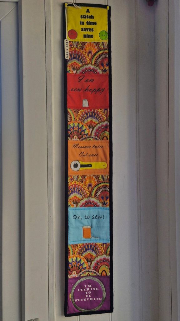 Wall hanging with mottos about sewing