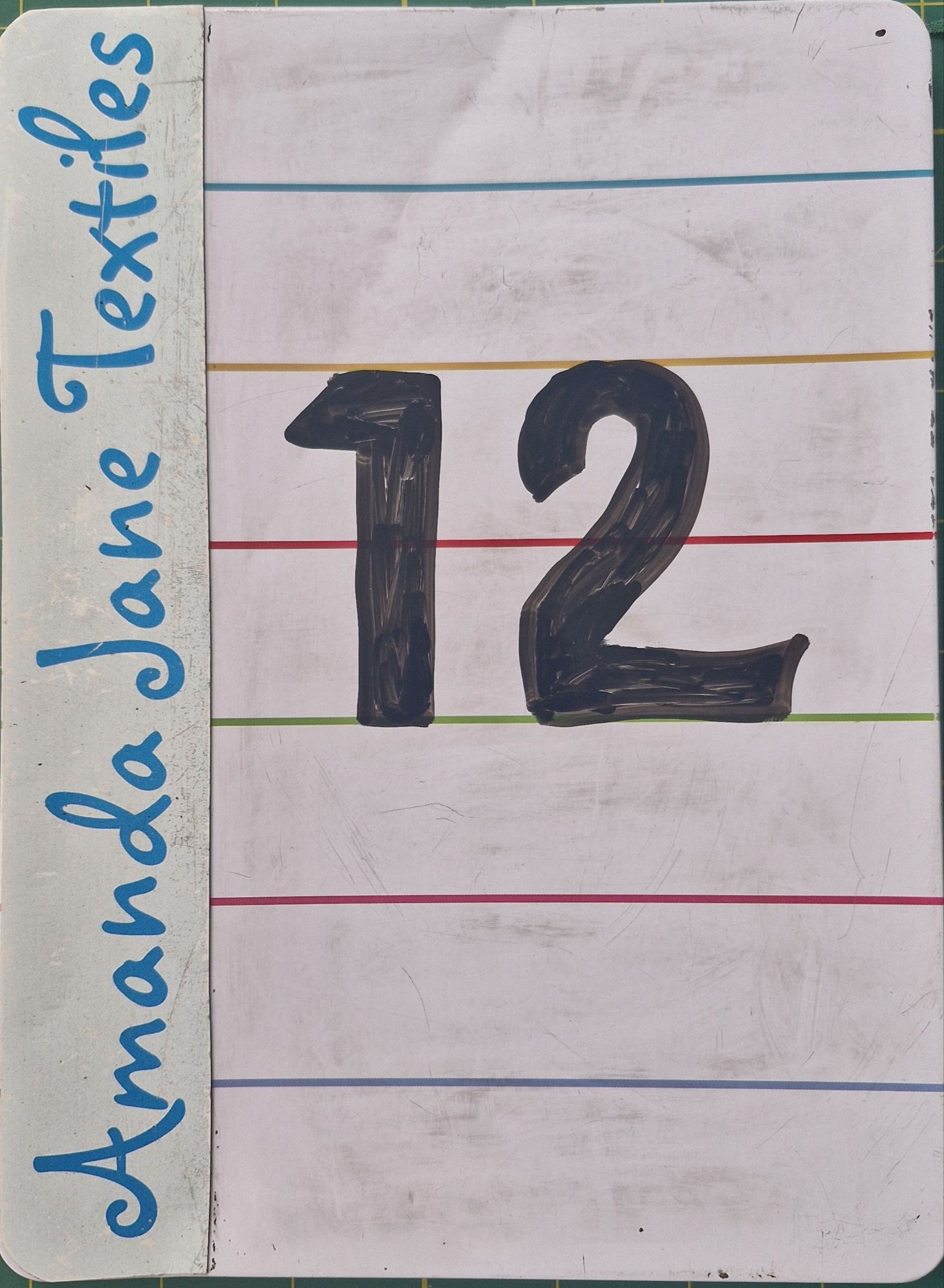 The number 12 written on a small whiteboard, photo by Amanda Jane Ogden